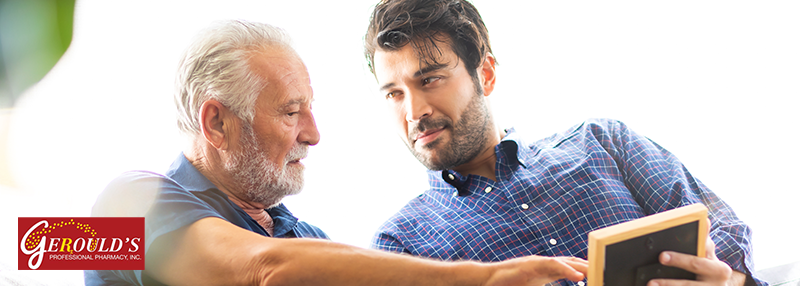 Senior man looking at photo with his adult son