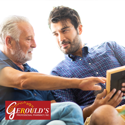 Senior man looking at photo with his adult son