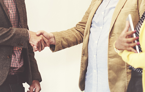 couple shaking hands with man